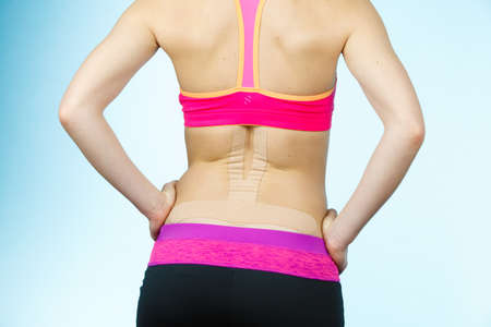 Woman with kinesiotaping application for back pain. Backache alternative kinesio tape therapy method. Health and body care.の写真素材