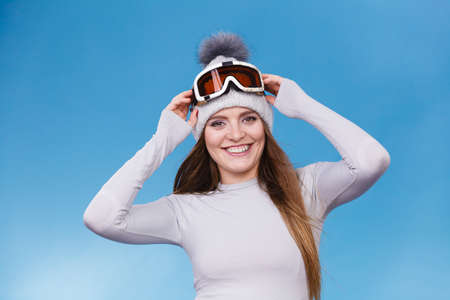 Attractive woman in winter cap gray sports thermal underwear for skiing training ski googles studio...