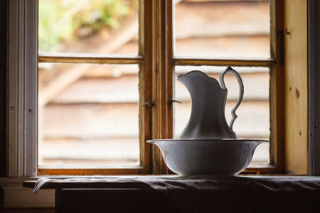 Old vintage objects, wood concept. Old vintage window and ceramic jug in foregroundの写真素材