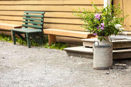 Bouquets, floristry concept. Composition of flowers in old clay pitcher standing outsideの写真素材