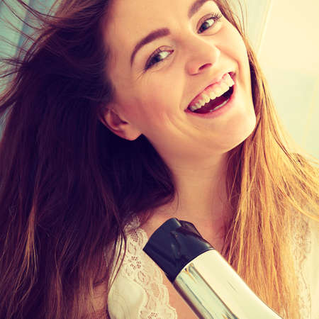 Haircare. Beautiful long haired woman drying hair in bathroomの写真素材