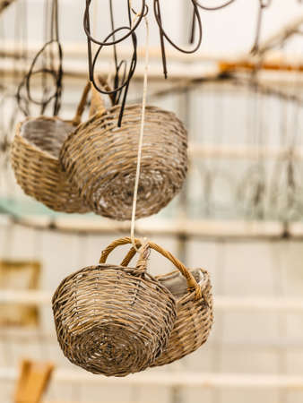 Handmade objects concept. Baskets made of wicker hanging under ceiling in greenhouseの写真素材