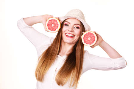 Woman attractive long hair girl colorful eyes makeup holding two halfs of grapefruit citrus fruit in hands. Healthy diet food. Summer holidays fun concept, on whiteの写真素材