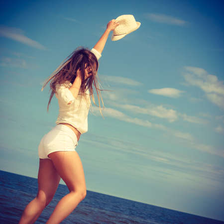 Happiness and craziness. Smiling crazy girl have fun outdoor. Young attractive long haired woman playing on summer beach.の写真素材