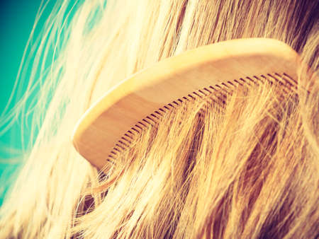 Haircare concept. Straight brown hair with wooden comb closeupの写真素材