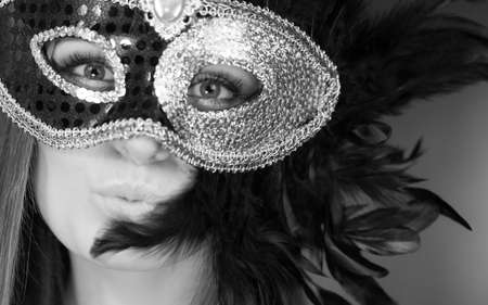 People, fashion, party concept. Sensual woman with carnival mask. Attractive young lady with long brown hair preaparing for celebration.の写真素材