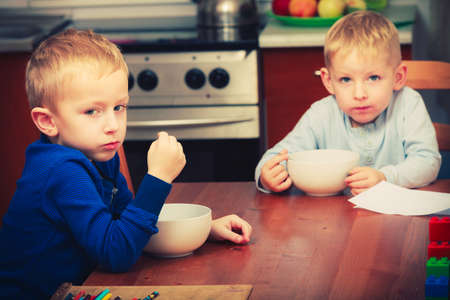 Morning routine in family, healthy diet for children concept. Two boys, kids eating breakfast together.の写真素材