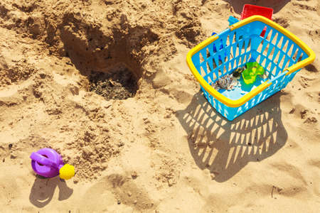 Summer fun time. Holidays and vacation. Childrens' toys lying on sand beach.の写真素材