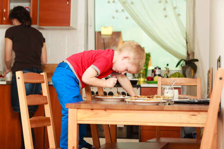 Morning routine in family, healthy diet for children concept. Little boy preparing pancakes for breaktfastの写真素材