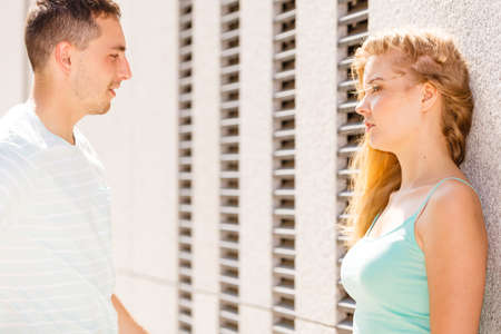 Flirt, love and passion concept. Man flirting with attractive blone girl on city street.の写真素材