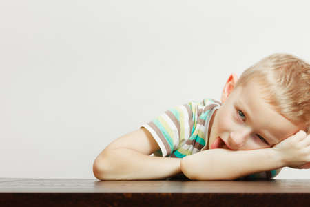 Boredom, face expression concept. Little boy making funny faces being bored, he wants to play with somebodyの写真素材