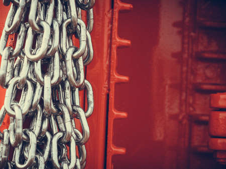 Abstract metal concept. Detailed closeup, lot of silver chains on red agriculture machinery