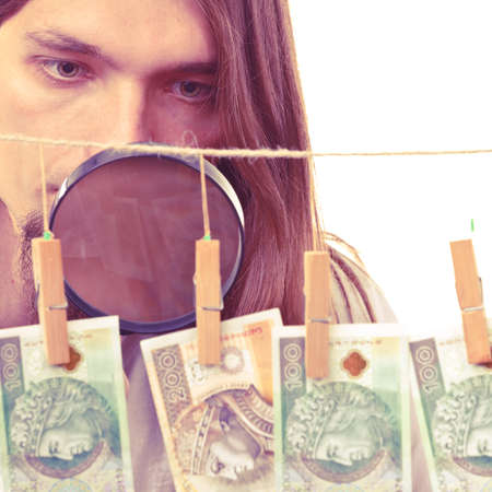 Currency exchange concept. Man worker check verify money cash. Payment hang on laundry line.の写真素材