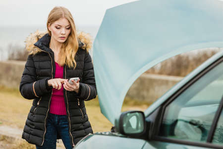 Accident and breakdowns with auto concept. Broken down car, blonde woman having problem, calling to...