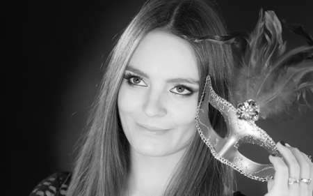 Party time, holidays, people and celebration concept. Woman long hair holding carnival mask close up. Black & white photoの写真素材