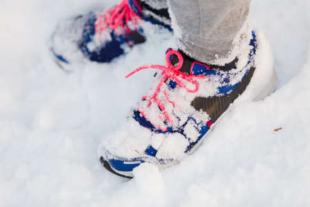Trainers covered in snow. Female shoes outdoors. Fashion clothing nature outdoor concept.の写真素材