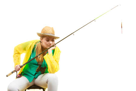 Fishery, spinning equipment, angling sport and activity concept. Bored woman with fishing rod, waiting for fish to hunt.の写真素材