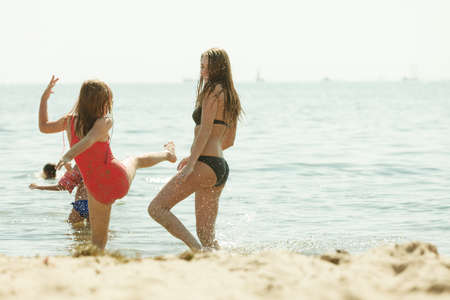Summertime joy, summer family recreation outside concept. Mother and her toddler daughter playing on beachの写真素材