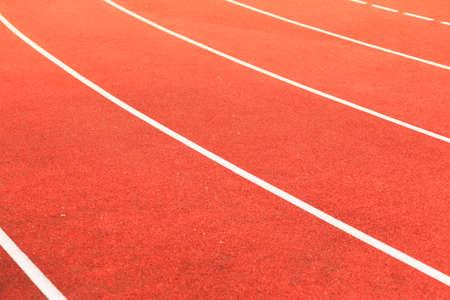 Empty red running track in stadium closeup