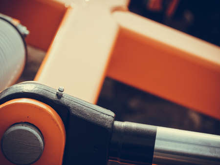 Industrial detailed pneumatic, hydraulic machinery concept. Pump made of steel on orange machine closeup.の写真素材