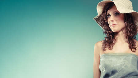 Fashion, cosmetics and summertime. Modern young woman with light green dress and summer hat.
