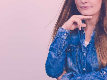 People fashion jeans concept. Attractive young lady wearing denim jacket. Pensively girl with long hair has nice outfit.の写真素材
