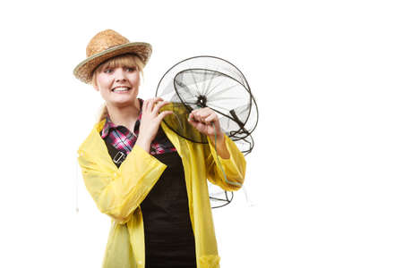 Spinning, angling, cheerful fisherwoman concept. Happy woman in yellow raincoat holding empty...