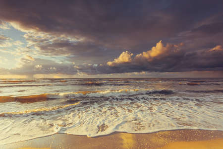 Amazing colorful sunset over evening sea horizon, clouds sky and sandy beach. Tranquil scene. Natural background. Landscape.の写真素材