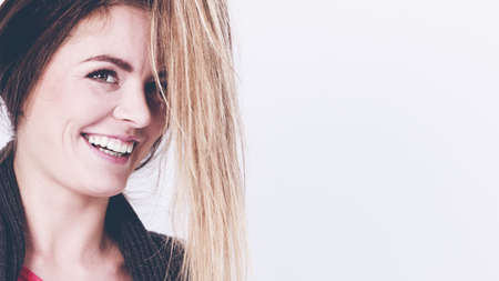 Cheerful girl with hanging hairs. Young smiling woman with hair next to face.  Fashion beauty coiffure lifestyle concept.の写真素材