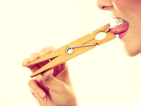 Language barrier, rumors, problems with expressing concept. Blonde woman having tongue in clothespinの写真素材