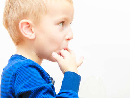 Tasty, yummy food for children concept. Boy licking something good from fingers.の写真素材