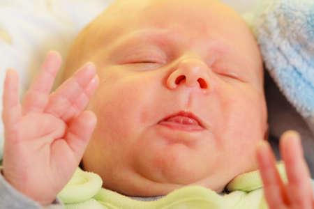 Infant care, beauty of childhood concept. Little newborn baby sleeping calmly in bed surrounded with...