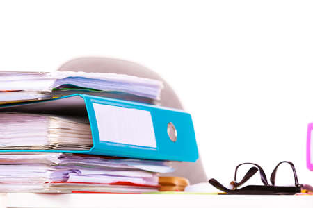 Paperwork. Stack of file folders, ring binders on office table dask.