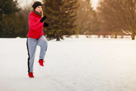 Outdoor sport exercises, sporty outfit ideas. Woman wearing warm sportswear training exercising outside during winter.の写真素材