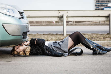 Auto assistance and insurance, troubles while traveling concept. Woman trying to repair her broken...