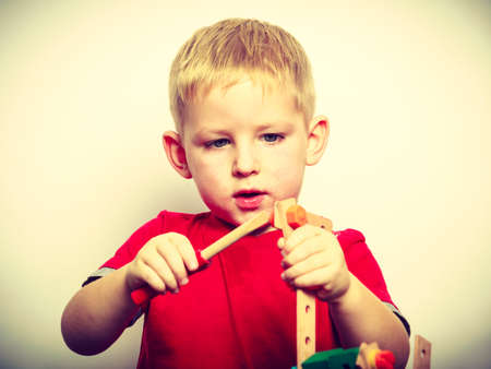 Childhood, kids imagination concept. Concentrated little boy playing with toys having funの写真素材