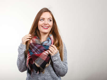 Portrait of long hair girl in gray sweater and warm woolen big scarf. Winter fashion.の写真素材