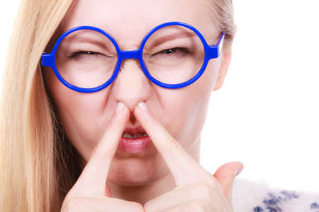 Stinky smells, clogged concept. Nerdy woman in big funny glasses holding nose smelling bad scent