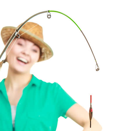 Fishery, spinning equipment, angling sport and activity concept. Happy smiling woman with fishing rod.の写真素材