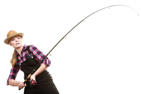 Spinning equipment, angling, cheerful fisherwoman concept. Focused woman in sun hat holding fishing rod hunting and fighting with fish on hookの写真素材