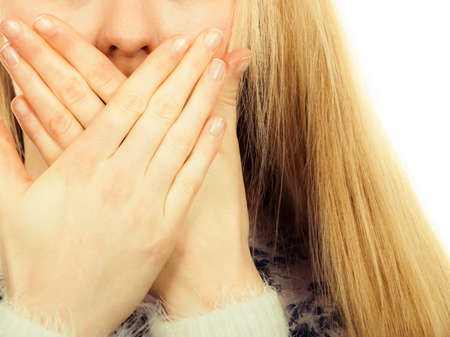 Face expression, human emotions concept. Shocked and surprised young blonde woman covering mouth...