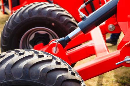 Agriculture equipment concept. Detailed closeup agricultural machinery, big wheels with tires. Outdoor shotの写真素材