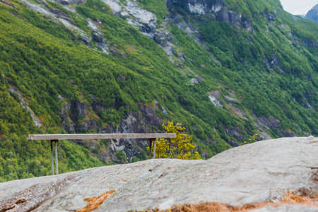 Tourism vacation and travel. Serene mountains landscape with rest place lonely bench, Norway Europe.の写真素材