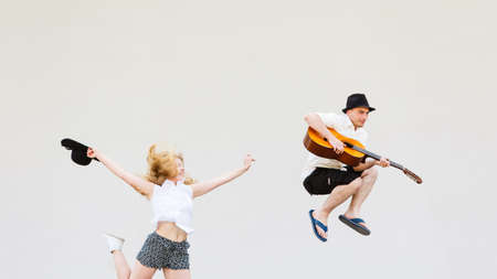 Relationship  concept. Couple on romantic date. Man with guitar and woman jumping