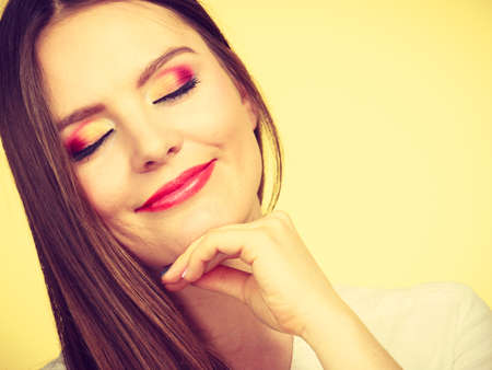Relaxation, time to think concept. Attractive smiling melancholy woman in brown hair with closed eyes and full makeup thinking and contemplating.の写真素材