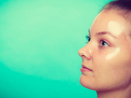 Close up young woman in facial peel off mask. Peeling. Beauty and skin care. Side viewの写真素材