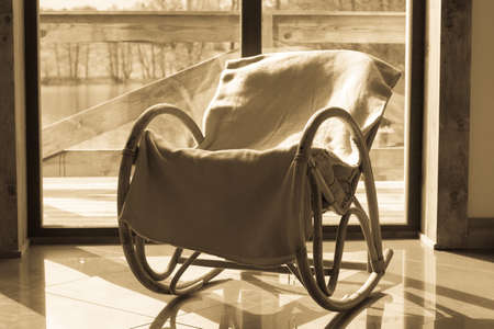 House furniture. Comfortable armchair with blanket on it in daylight with window in backgroundの写真素材