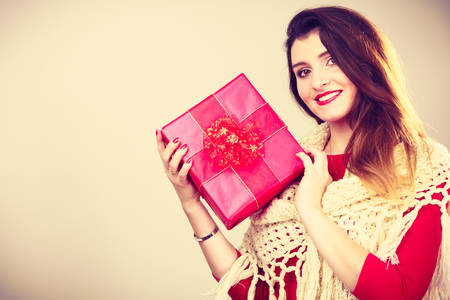 Girl checking out present.  Young attractive woman holding gift box. Christmas santa holidays...