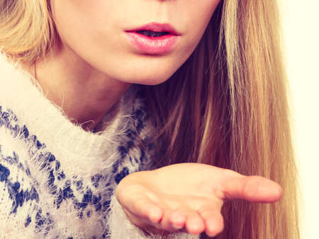 Gestures and human reactions concept. Coquet blonde womn sending air kiss on palm handの写真素材