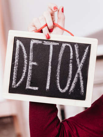 Dieting and detoxing, weight loss concept. Woman hand holding board with detox signの写真素材